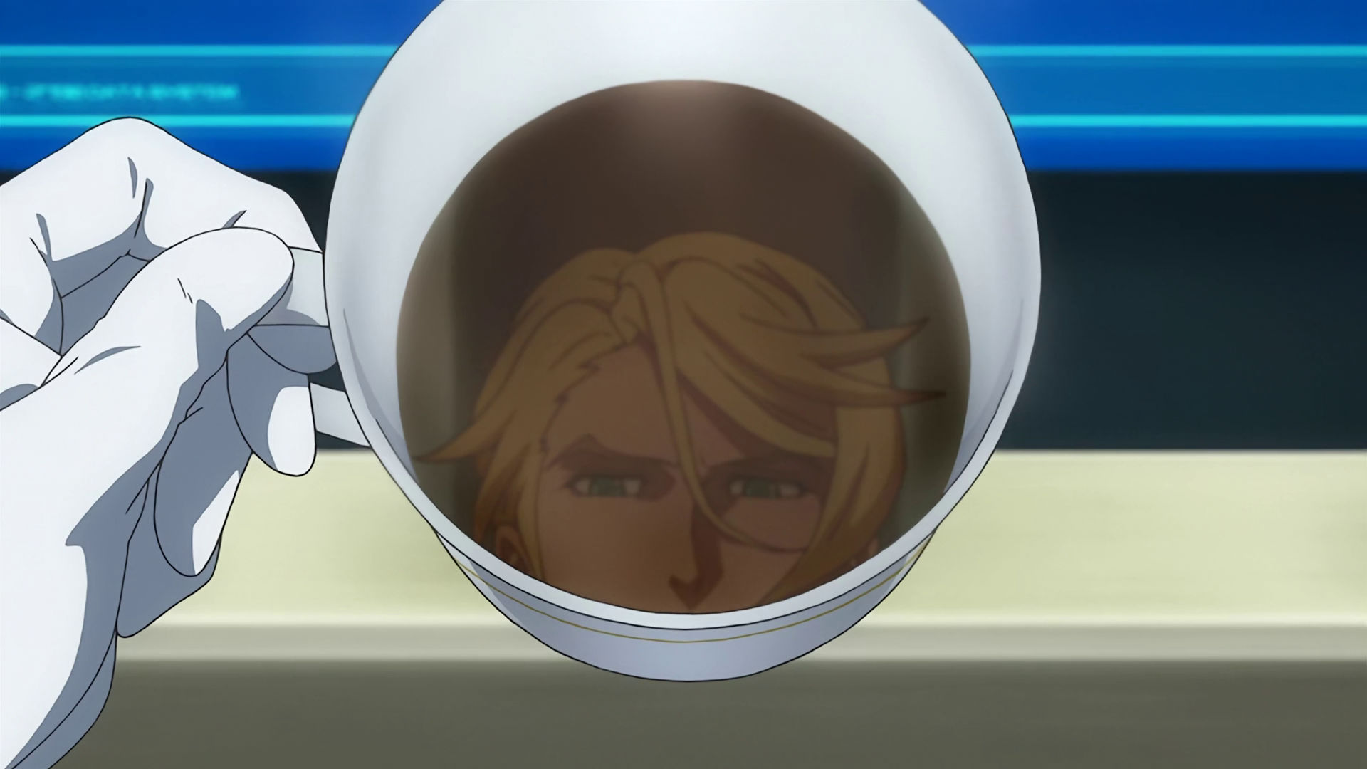 McGillis loking at a coffee mug showing his own reflection.