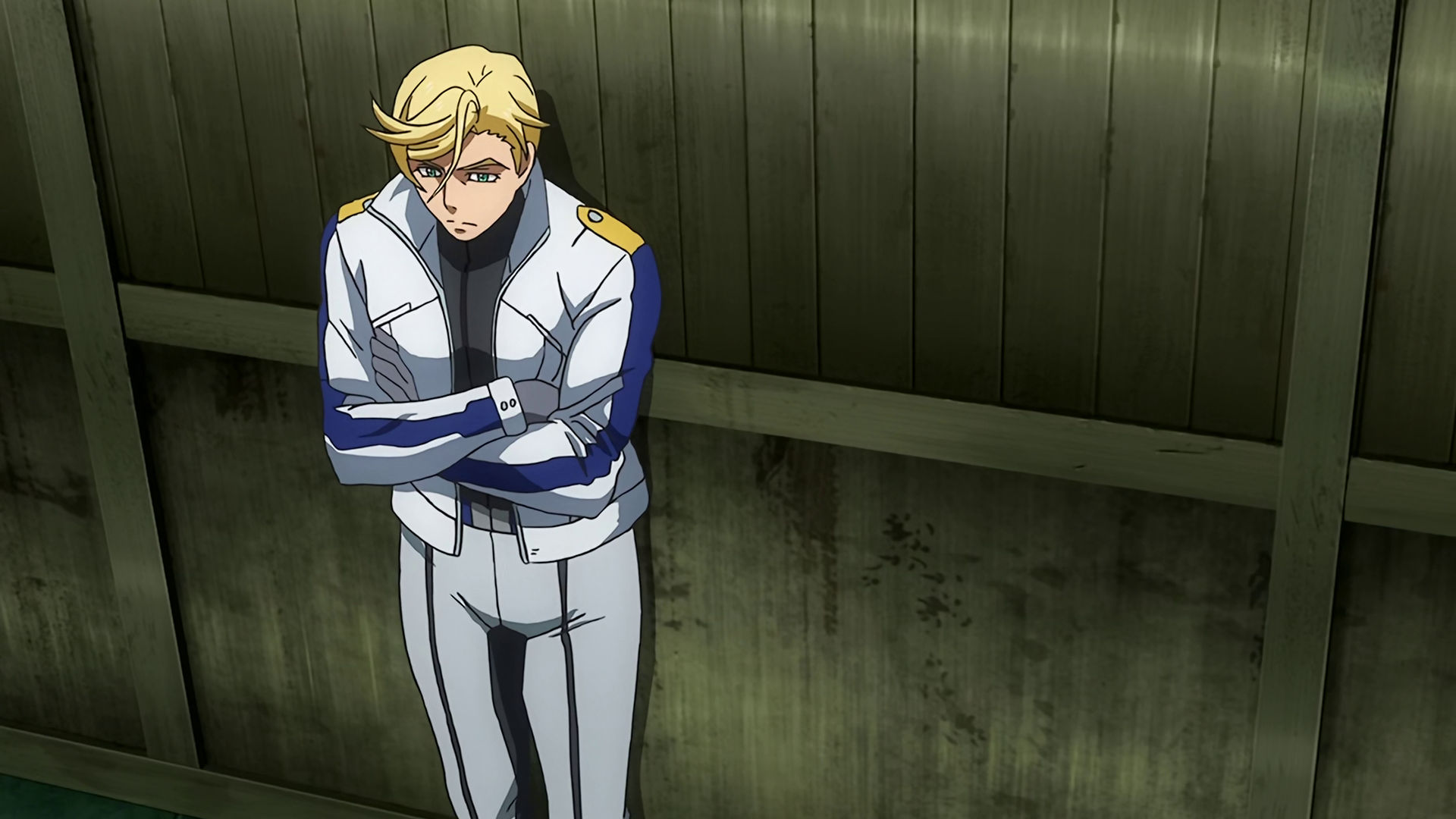 McGillis leaning back on a wall with his arms crossed and wearing an white and blue sport jacket