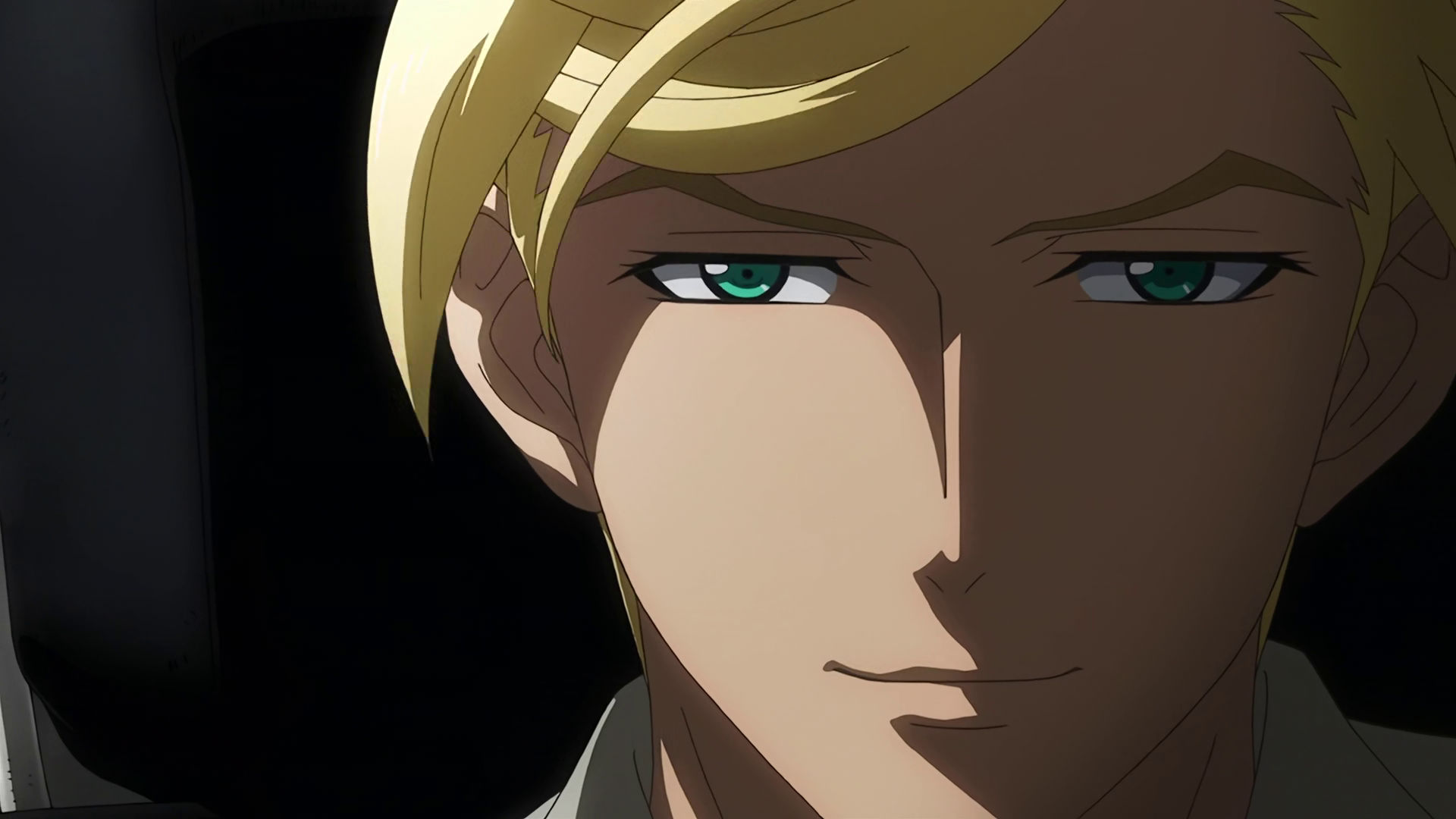 A closeup of McGillis face, only the left side of his face is being illuminated, he's got a devious look on his face 