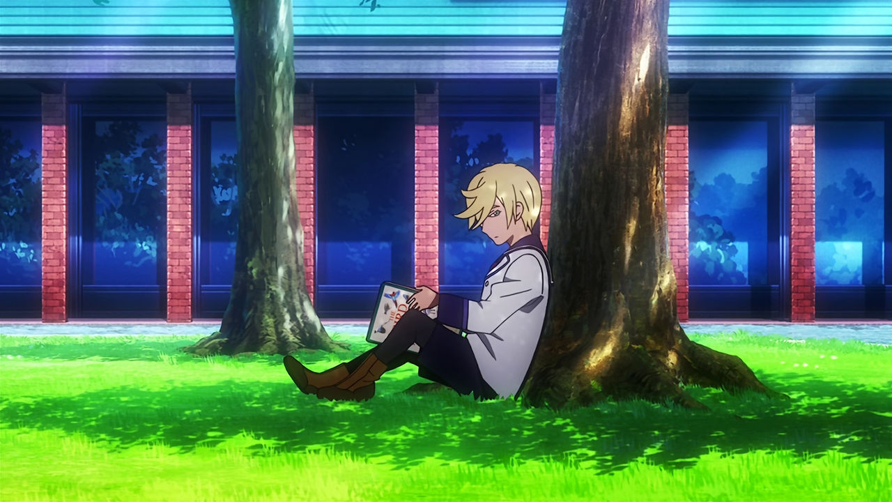 A young McGillis sitting bellow a tree holding a book