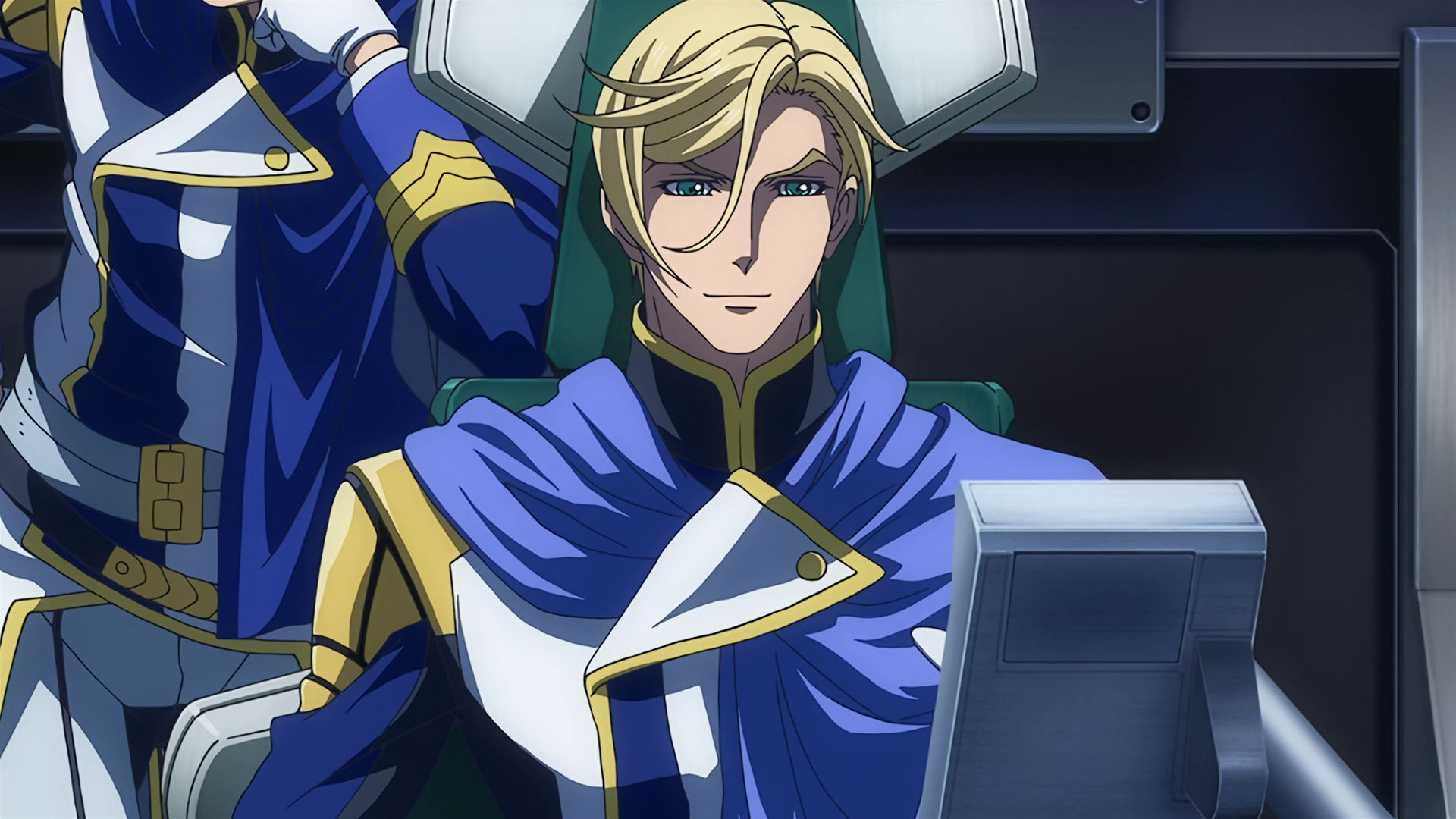 McGillis sitting in a chair, someone is behind him leaning on his chair