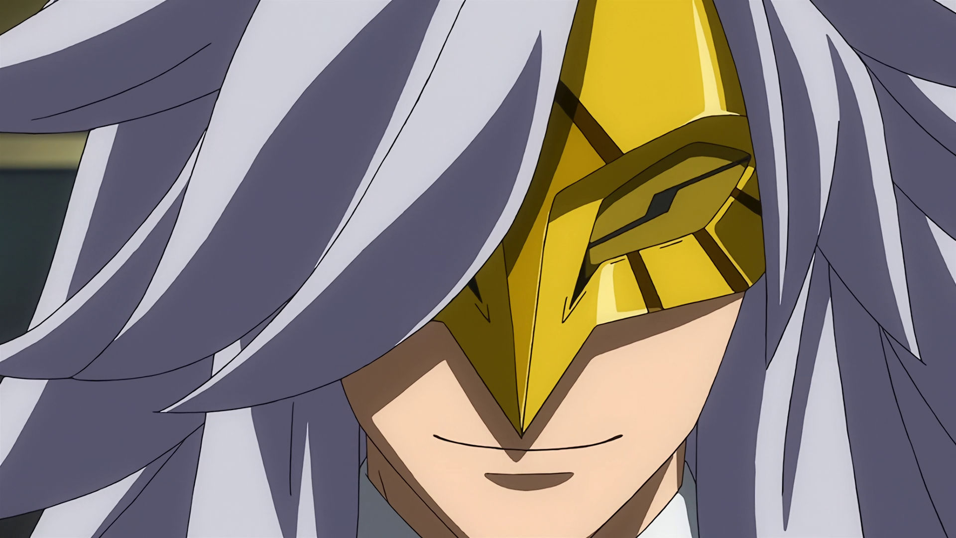 McGillis wearing a golden mask with long gray hair, his eyes are hidden by the mask and he is smiling. 