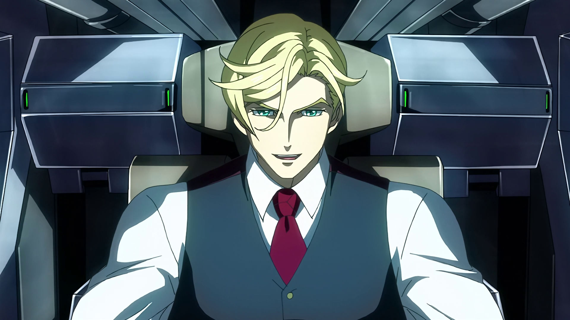 McGillis inside a mobile suit cockpit, he is smiling.