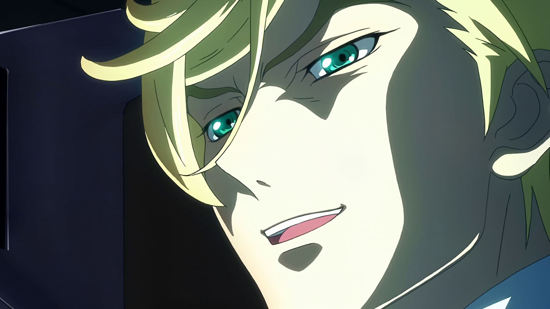 Closeup of McGillis' face inside a mobile suit cockpit, he is smiling.