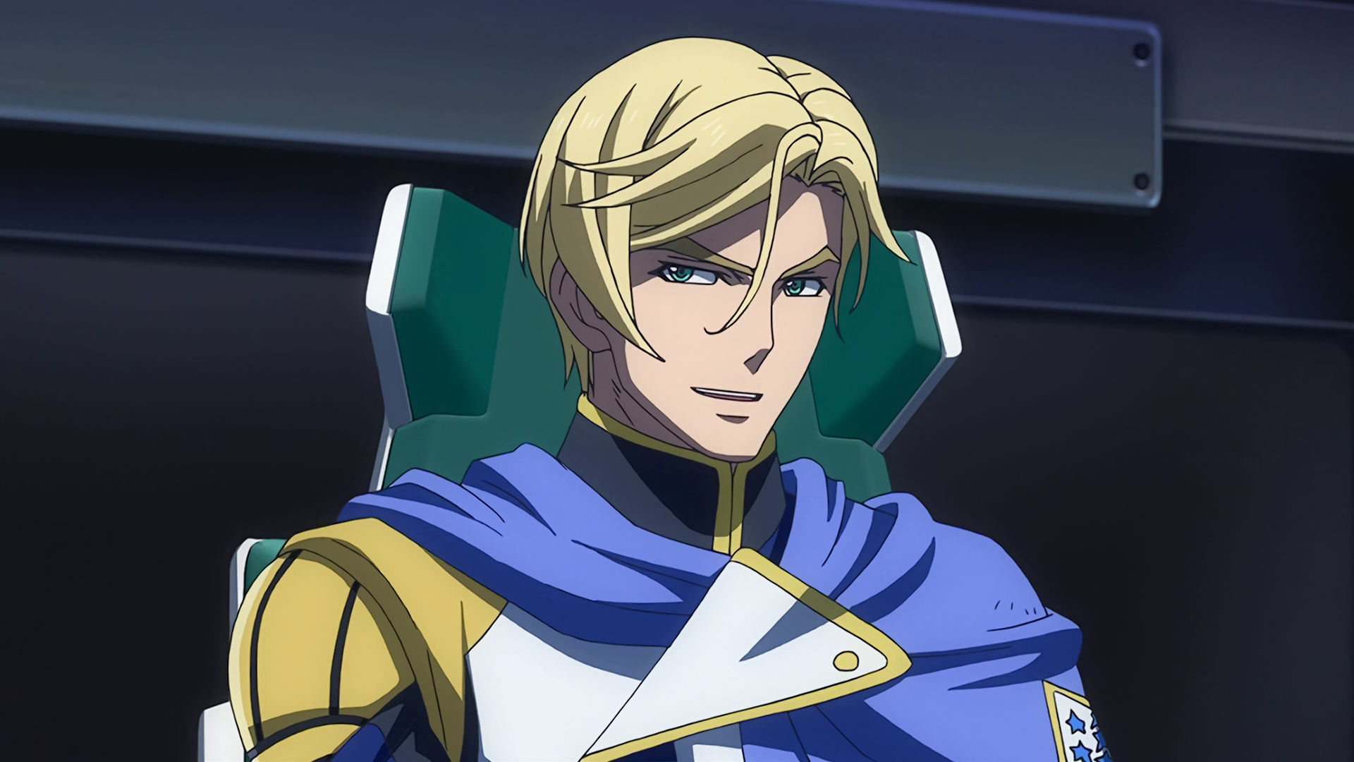 McGillis sitting on a chair, he is smiling 