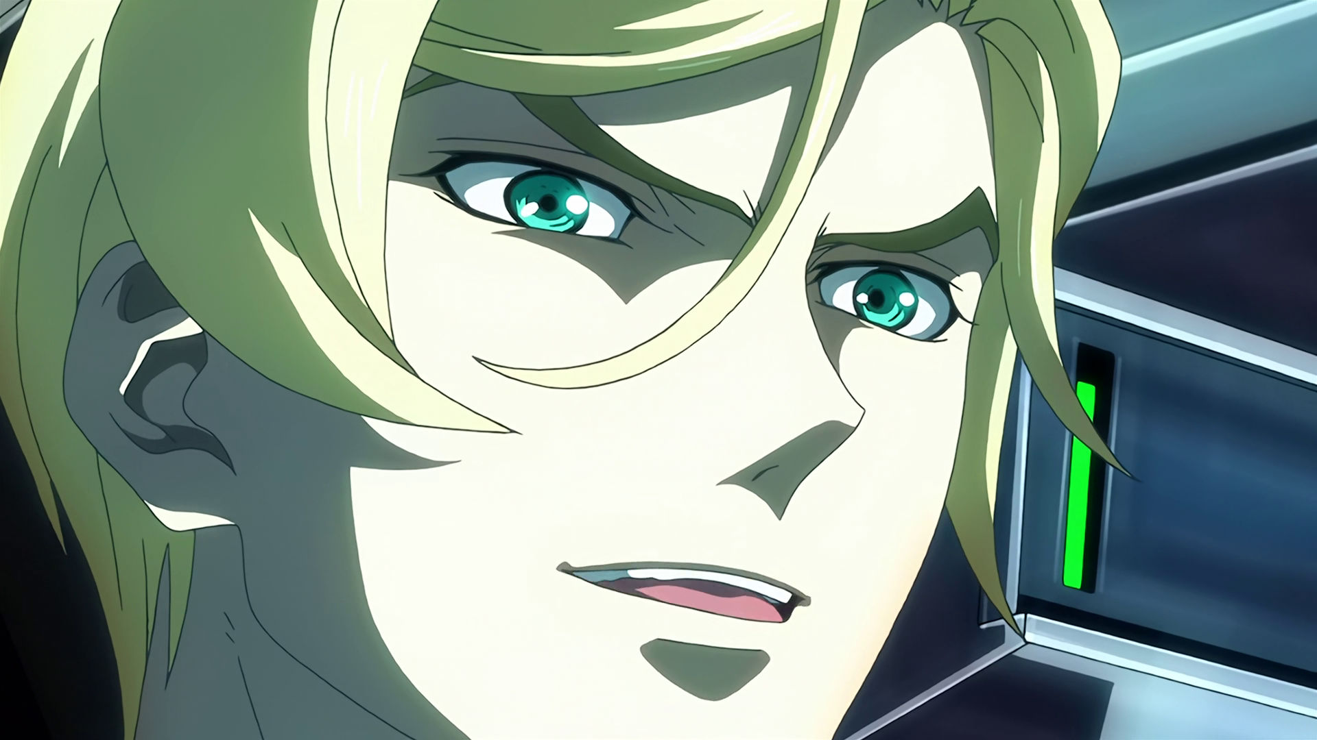 Closeup of McGillis' face inside a mobile suit cockpit, he is smiling.