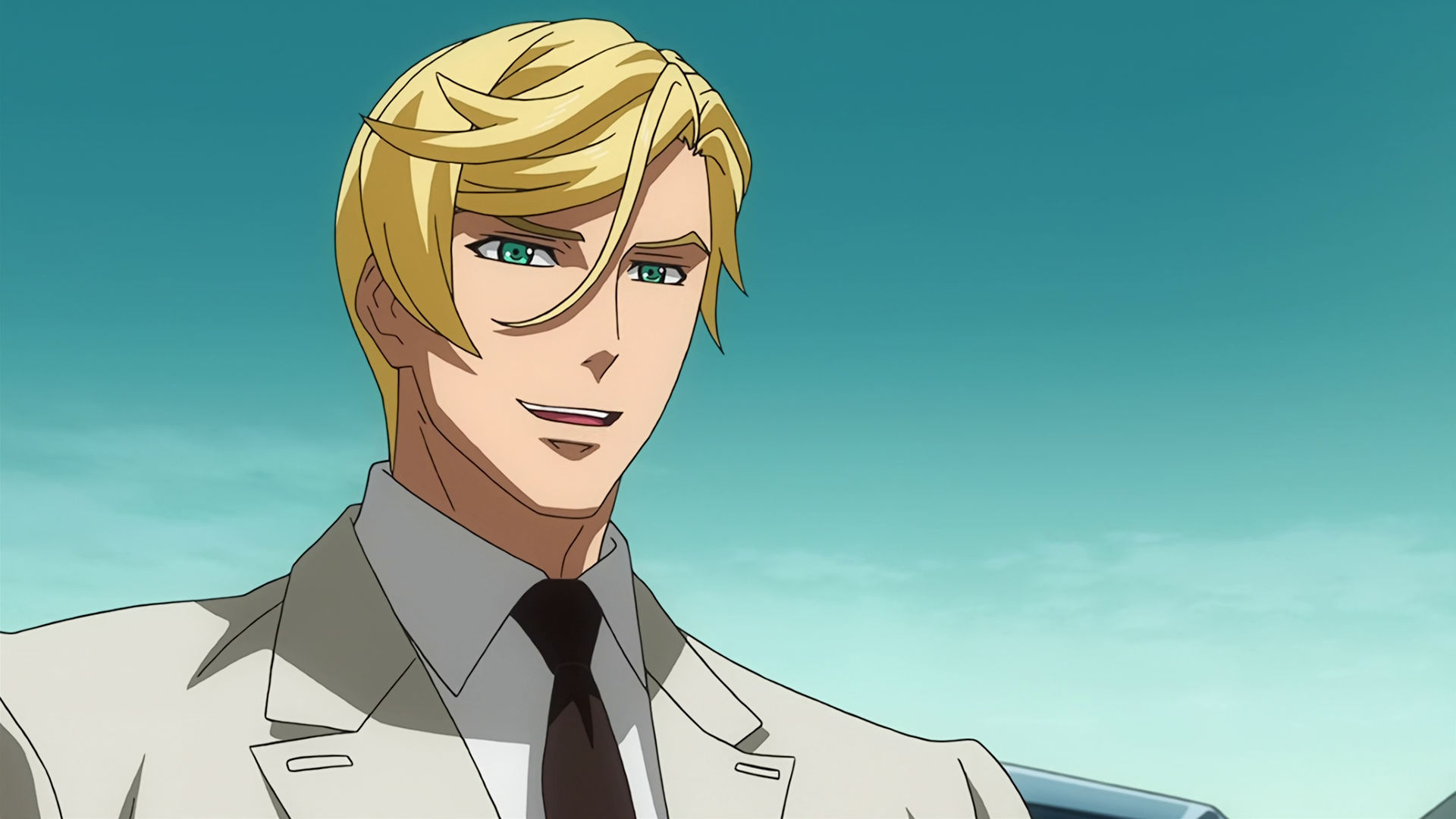 McGillis wearing an off-white suit, he is smiling.