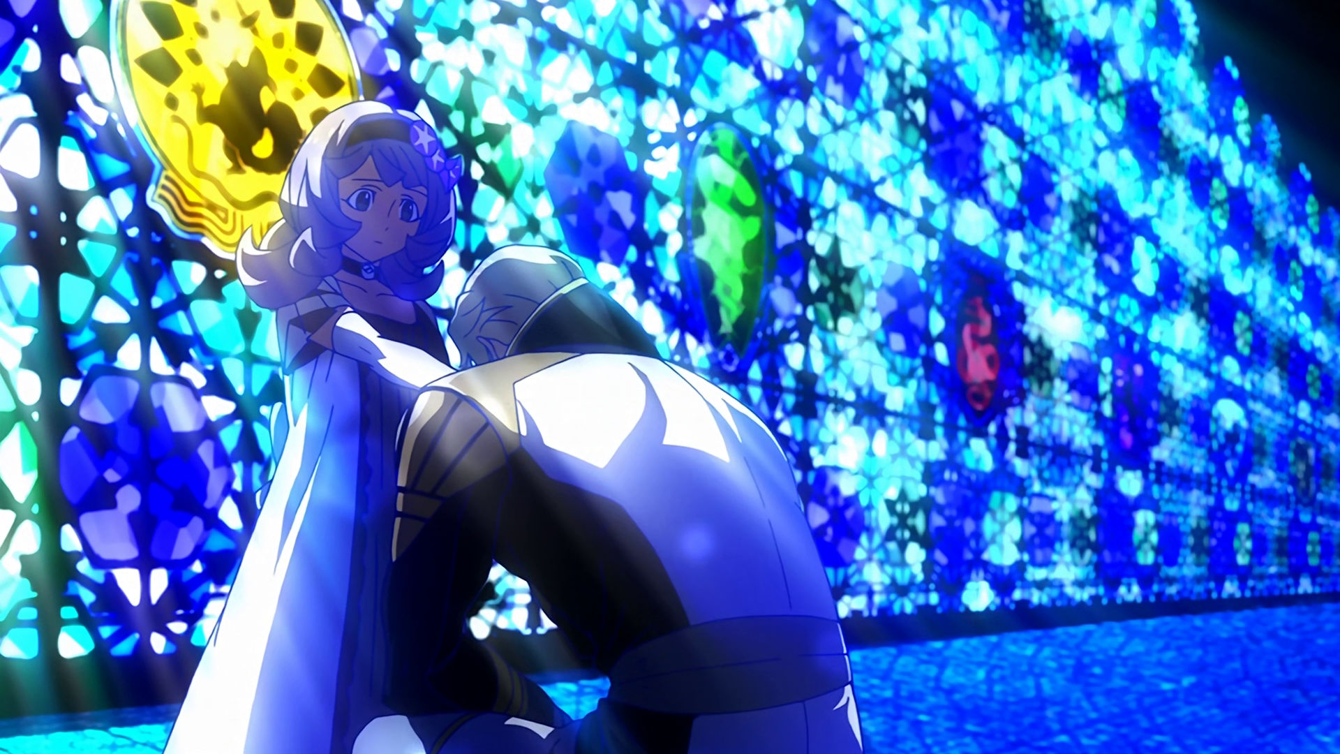 McGillis kneeling in front of Almiria holding her hand in front of a blue glass mosaic wall